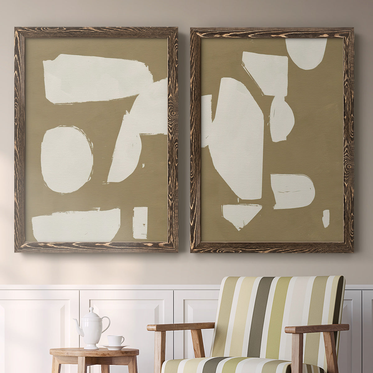 Set of two walnut barnwood framed canvas prints depicting two bold minimalist shape abstracts featuring irregular white cutout-like shapes on taupe grounds above a sideboard in a cozy sitting room.