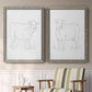 Set of two gray barnwood framed canvas prints depicting two minimalist livestock sketches featuring simple contour drawings of standing cows above a sideboard in a cozy sitting room.