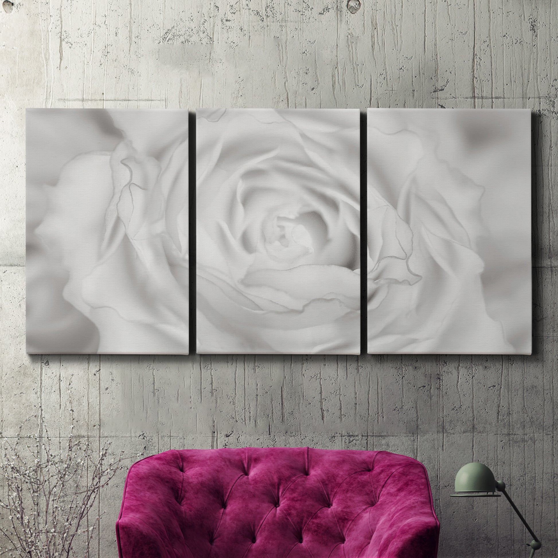 Three-panel canvas wall art featuring monochrome rose study photograph, displayed in a living room above a suede accent chair.