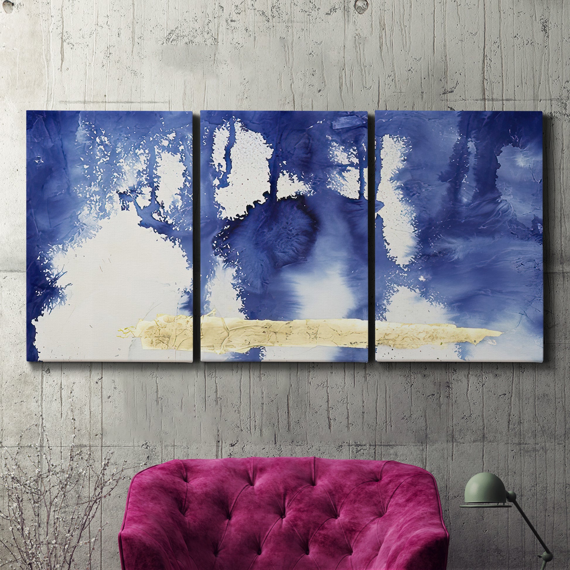 Three-panel canvas wall art featuring saturated abstract color fields, displayed in a living room above a suede accent chair.