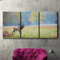 Three-panel canvas wall art featuring resting animals in open field, displayed in a living room above a suede accent chair.