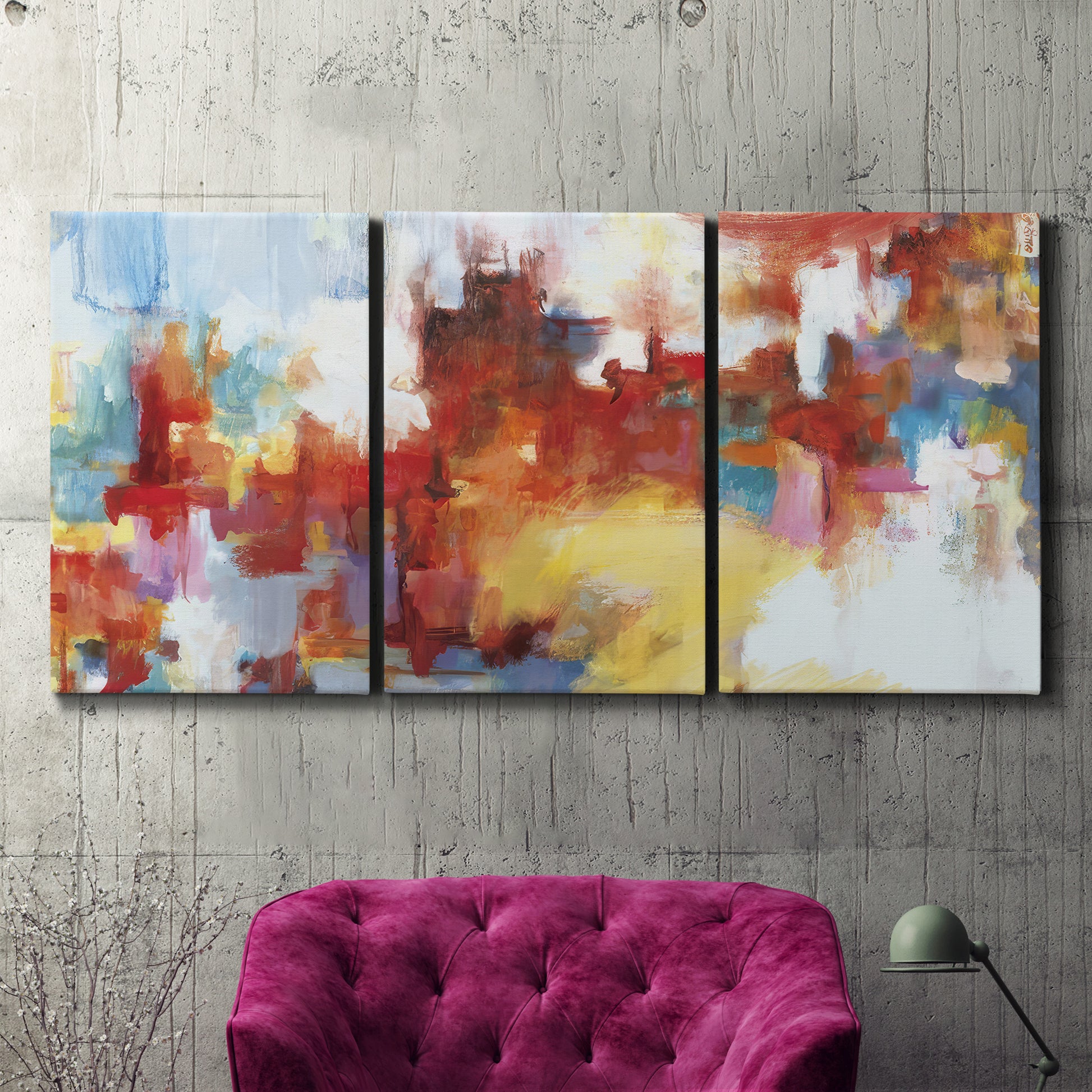 Three-panel canvas wall art featuring abstract city lights composition, displayed in a living room above a suede accent chair.