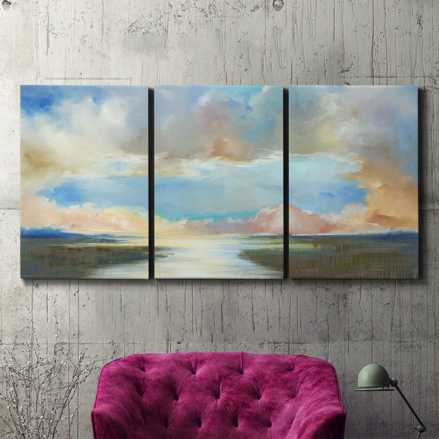 Three-panel canvas wall art featuring dawn light breaking over water, displayed in a living room above a suede accent chair.