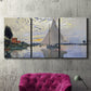 Three-panel canvas wall art featuring riverside village shoreline, displayed in a living room above a suede accent chair.