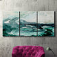 Three-panel canvas wall art featuring coastal abstract sea foam movement, displayed in a living room above a suede accent chair.