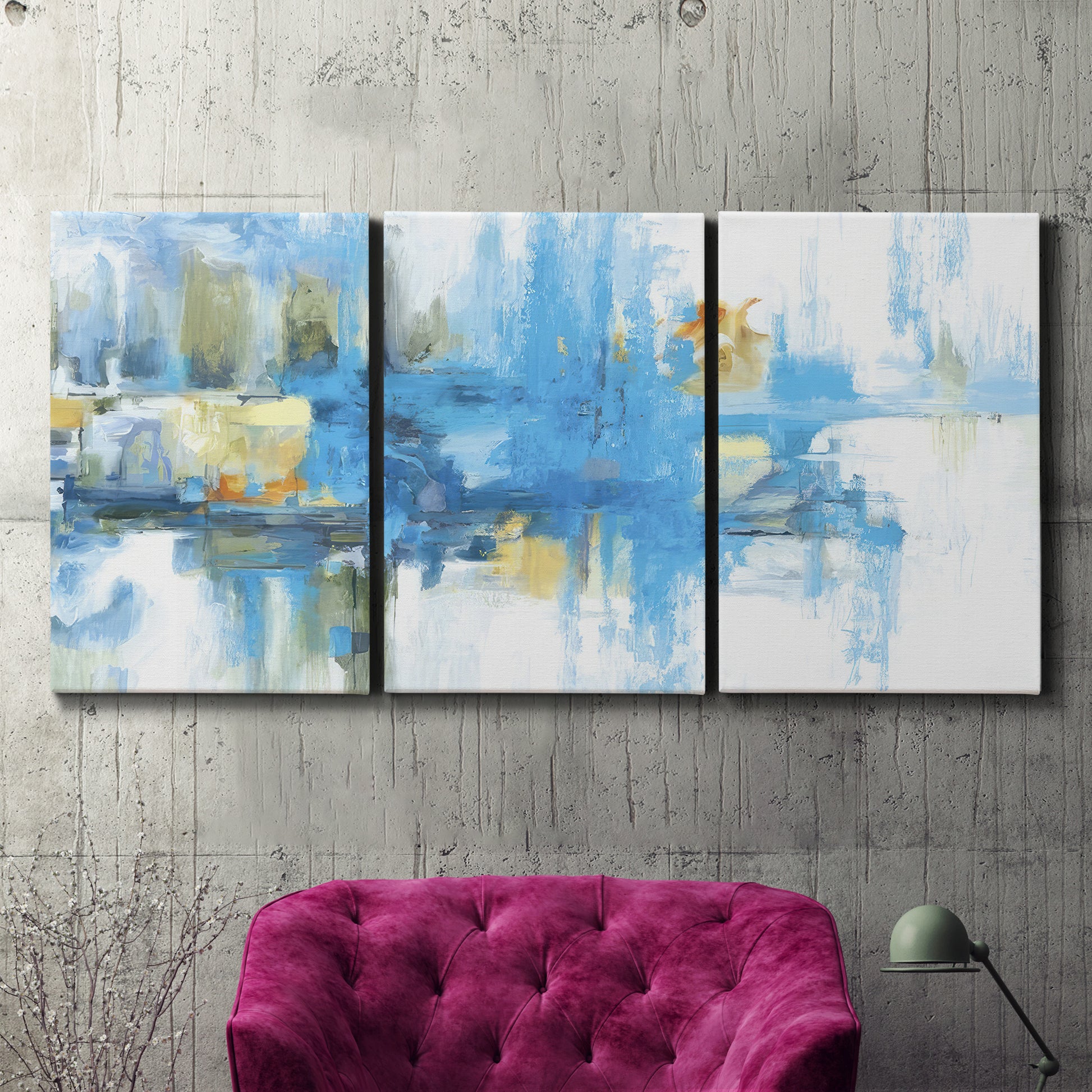 Three-panel canvas wall art featuring blue toned abstract city rhythm, displayed in a living room above a suede accent chair.