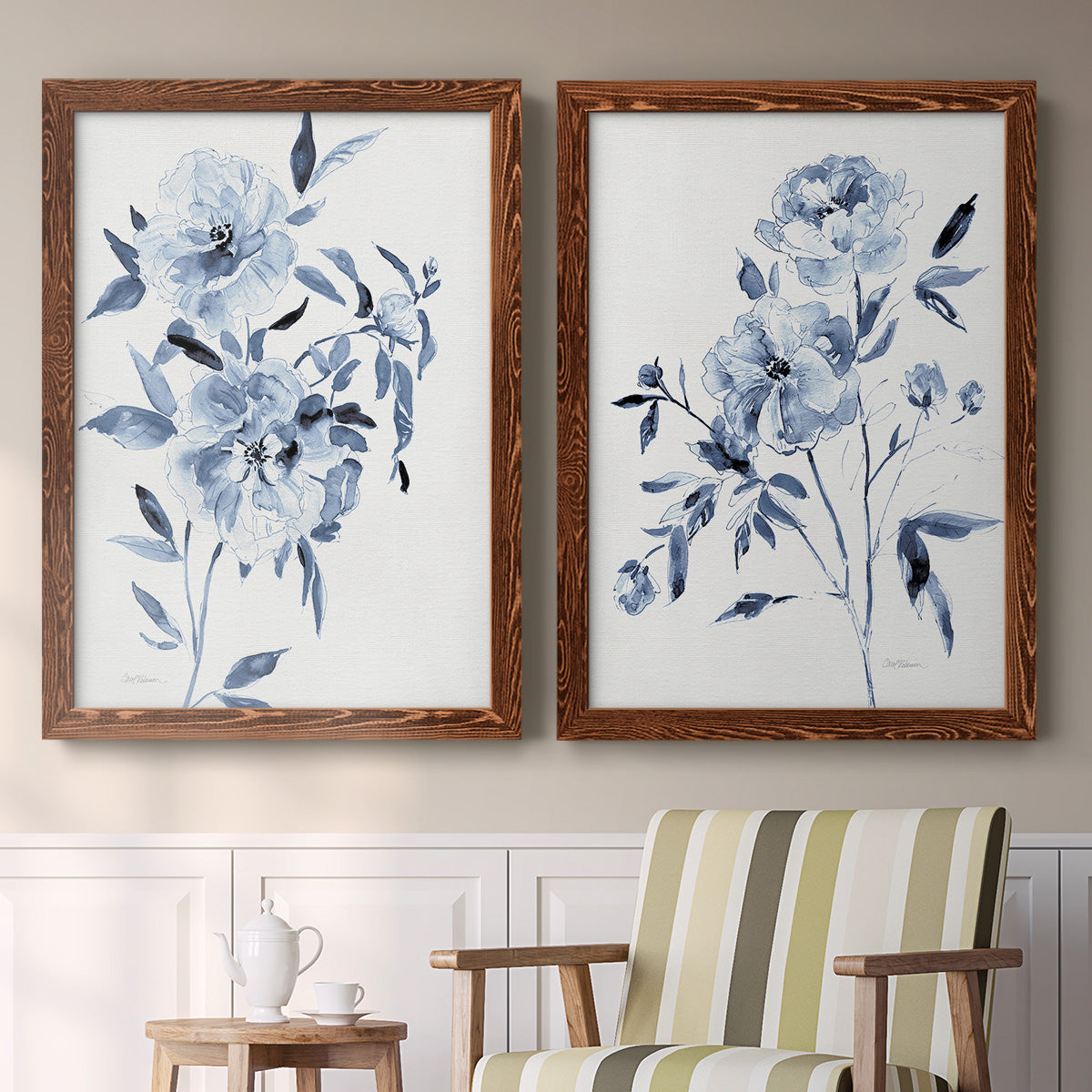 Set of two maple barnwood framed canvas prints depicting two expressive watercolor botanical paintings featuring loose blue flowers and leafy branches above a sideboard in a cozy sitting room.
