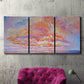Three-panel canvas wall art featuring peaceful tropical inspired landscape, displayed in a living room above a suede accent chair.
