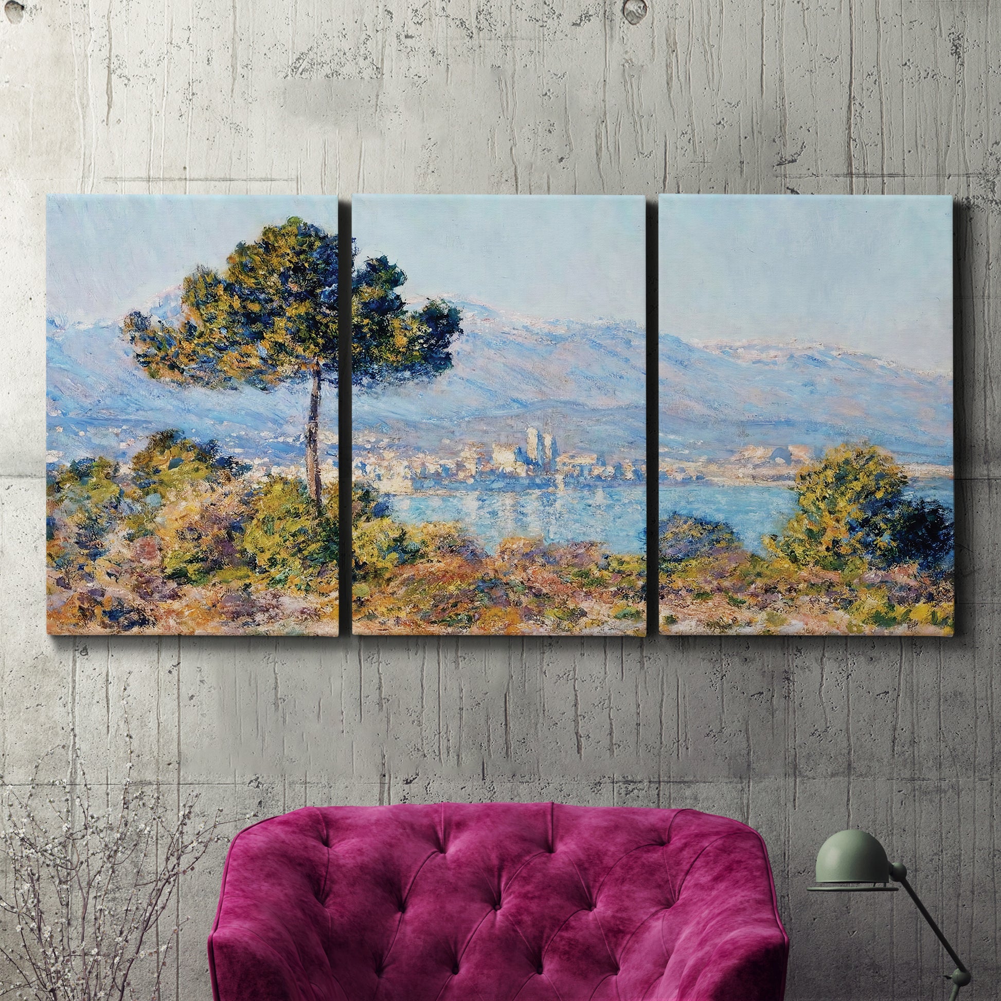 Three-panel canvas wall art featuring coastal town viewed from hillside, displayed in a living room above a suede accent chair.