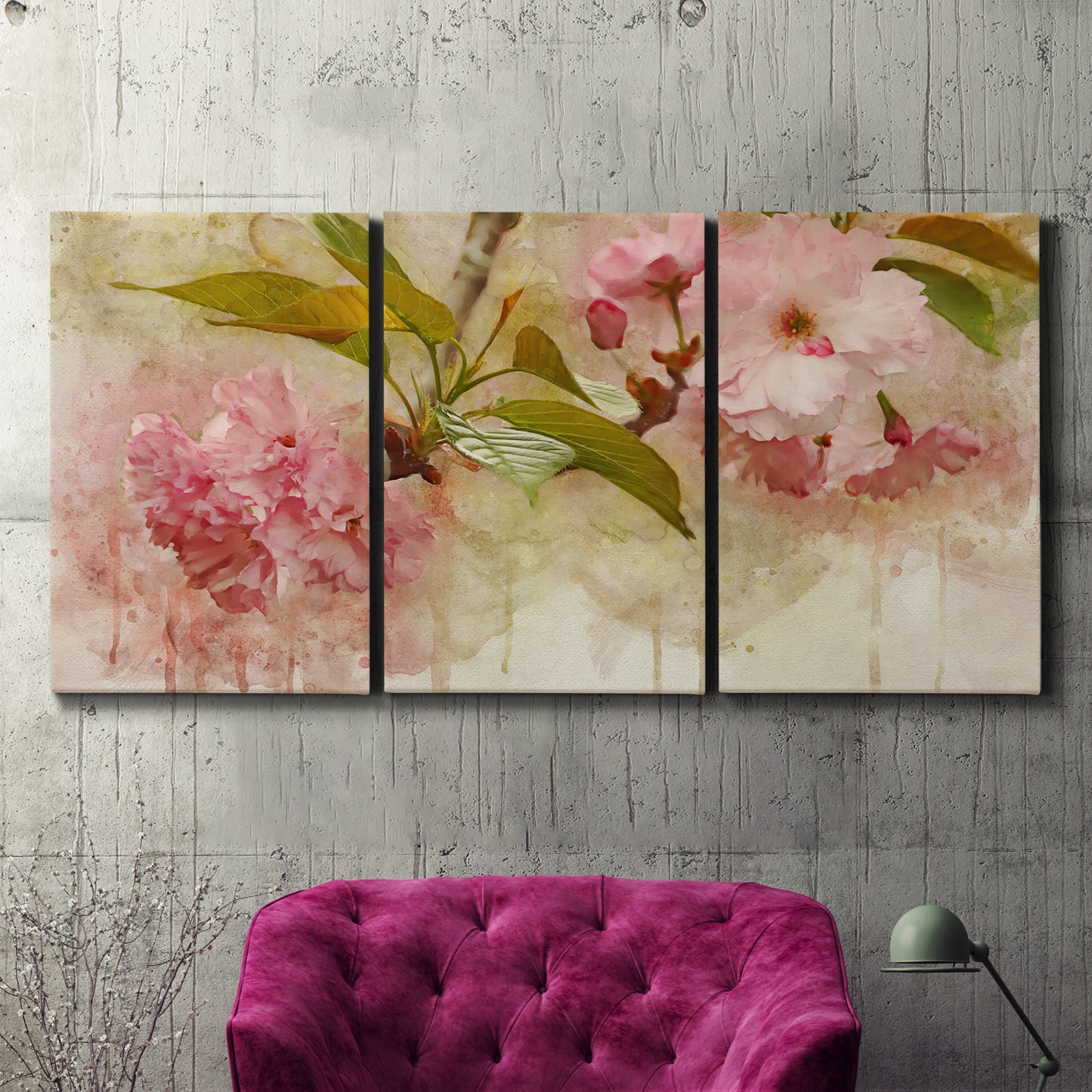 Three-panel canvas wall art featuring soft floral blossom composition, displayed in a living room above a suede accent chair.