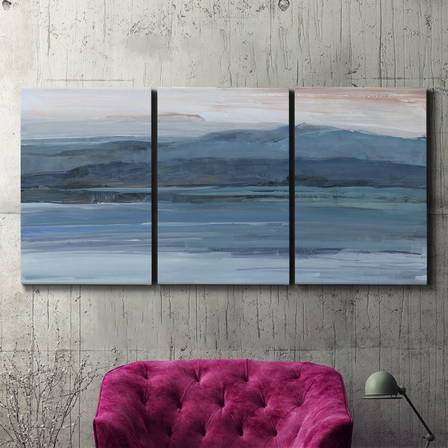 Three-panel canvas wall art featuring wide lake with distant shoreline, displayed in a living room above a suede accent chair.