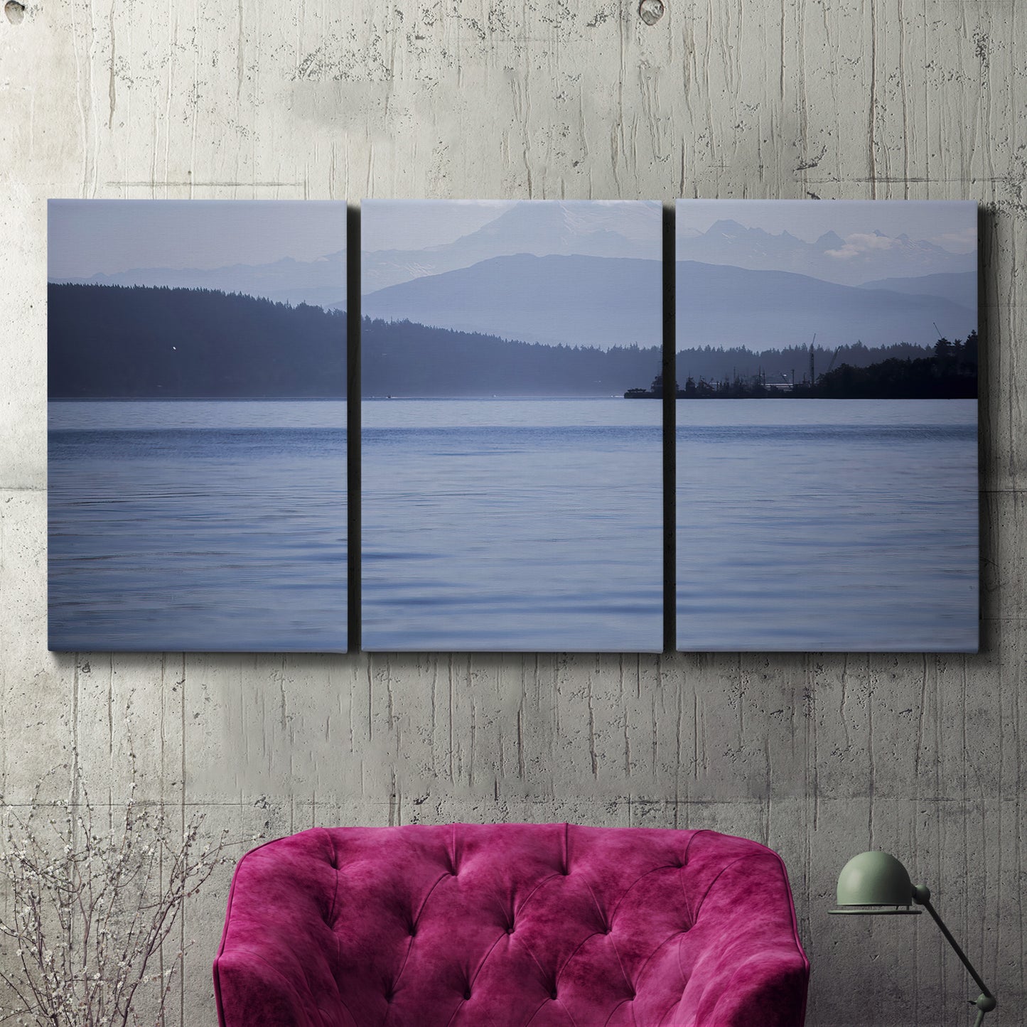 Three-panel canvas wall art featuring calm blue water landscape, displayed in a living room above a suede accent chair.