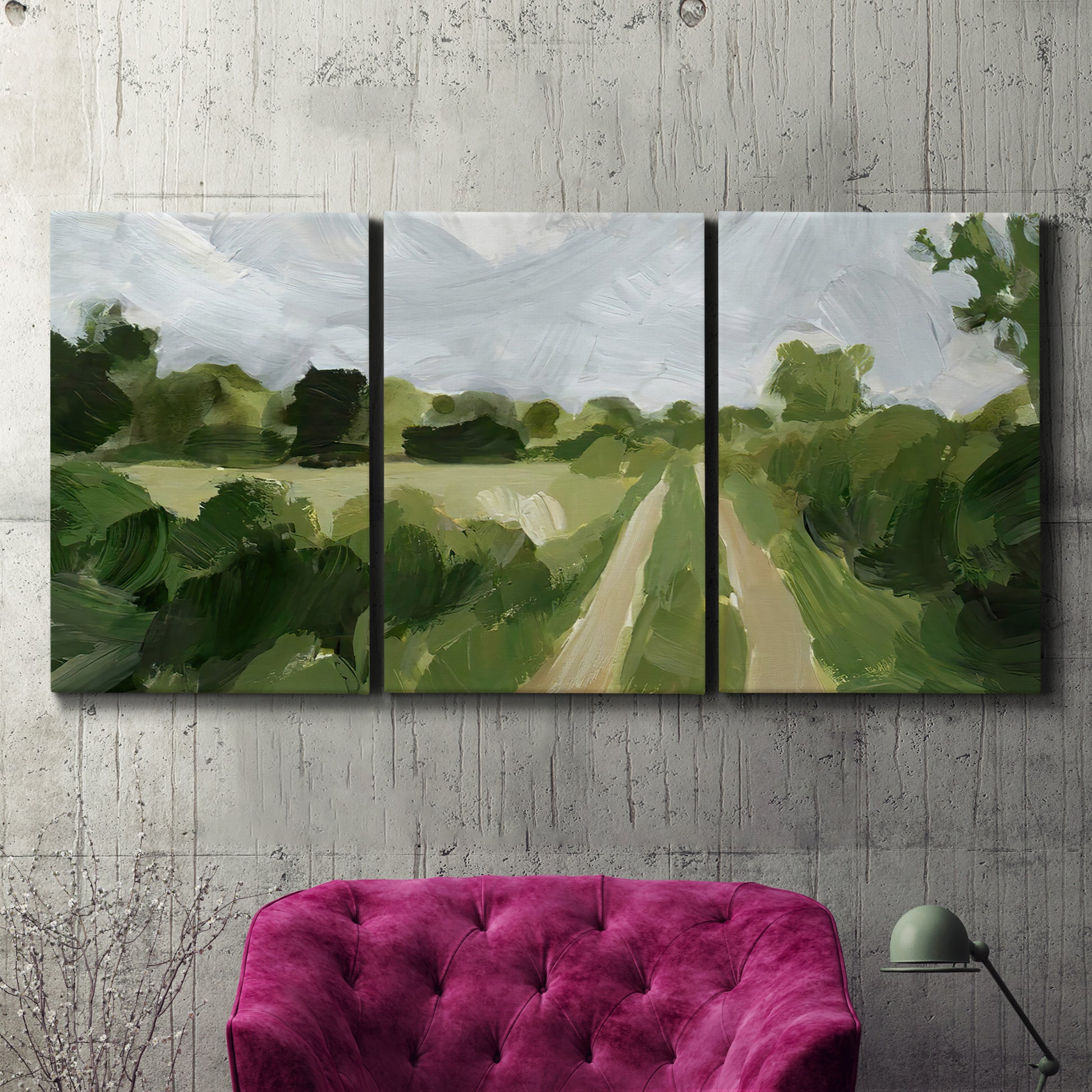 Three-panel canvas wall art featuring meadow trail through open grassland, displayed in a living room above a suede accent chair.