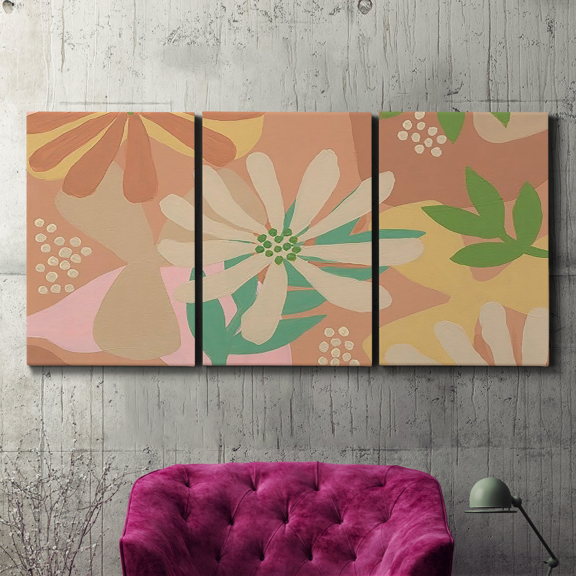 Three-panel canvas wall art featuring neutral toned botanical floral silhouettes, displayed in a living room above a suede accent chair.