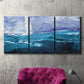 Three-panel canvas wall art featuring impressionist nautical harbor scene, displayed in a living room above a suede accent chair.