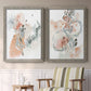 Set of two gray barnwood framed canvas prints depicting two abstract watercolor botanicals featuring loose blush gray and coral floral gestures above a sideboard in a cozy sitting room.