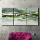 Three-panel canvas wall art featuring abstract passage of time composition, displayed in a living room above a suede accent chair.