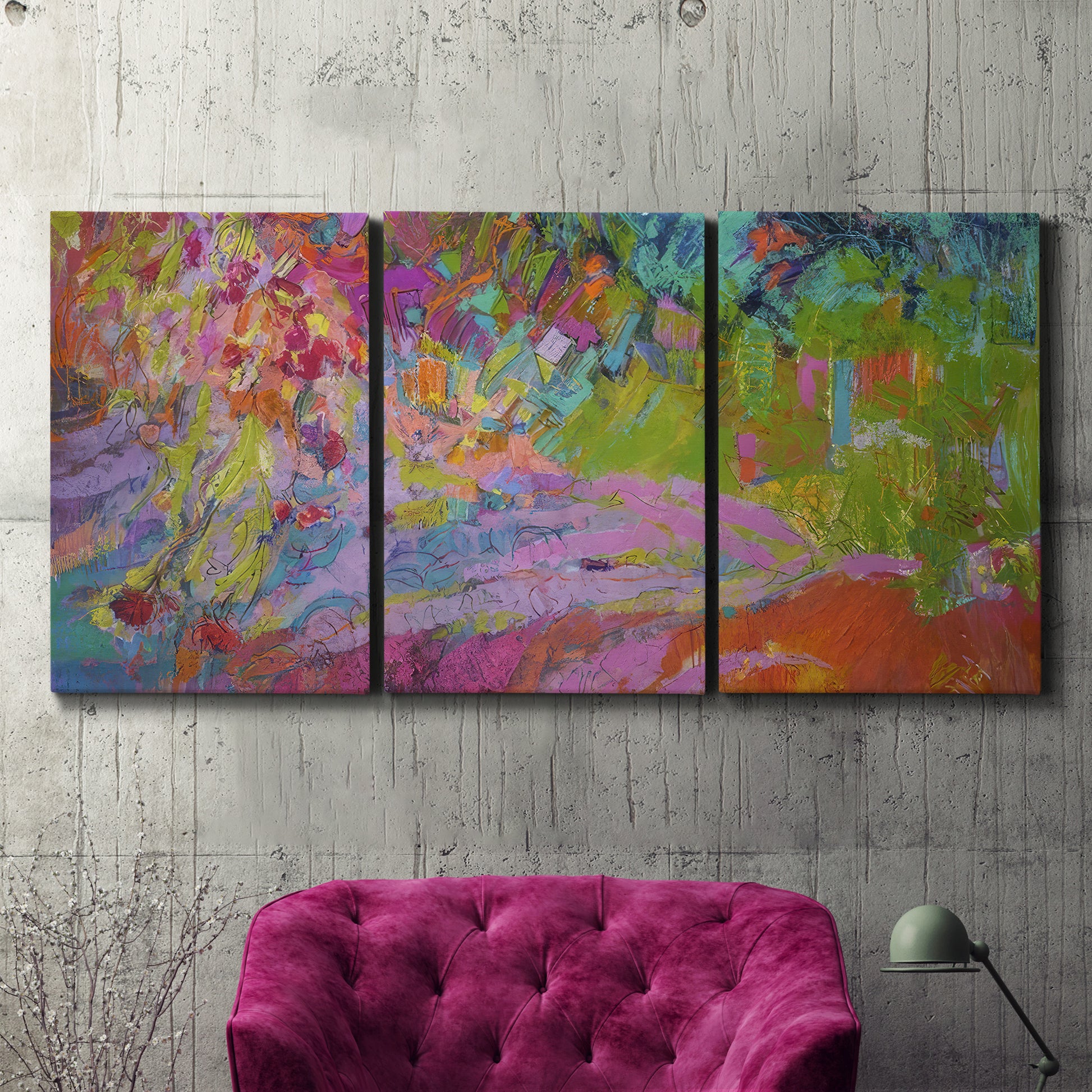 Three-panel canvas wall art featuring vibrant abstract with dramatic motion, displayed in a living room above a suede accent chair.