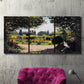 Three-panel canvas wall art featuring coastal garden overlooking sea, displayed in a living room above a suede accent chair.