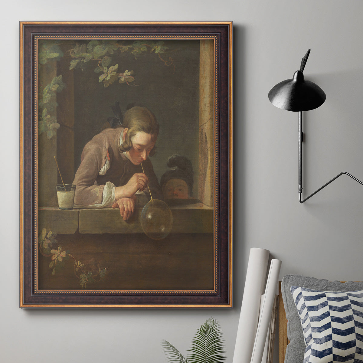 Classical genre painting of a child blowing soap bubbles by Jean-Siméon Chardin in an ornate bronzed mahogany wood frame displayed in a neutral interior setting.