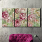 Three-panel canvas wall art featuring blooming climbing rose, displayed in a living room above a suede accent chair.