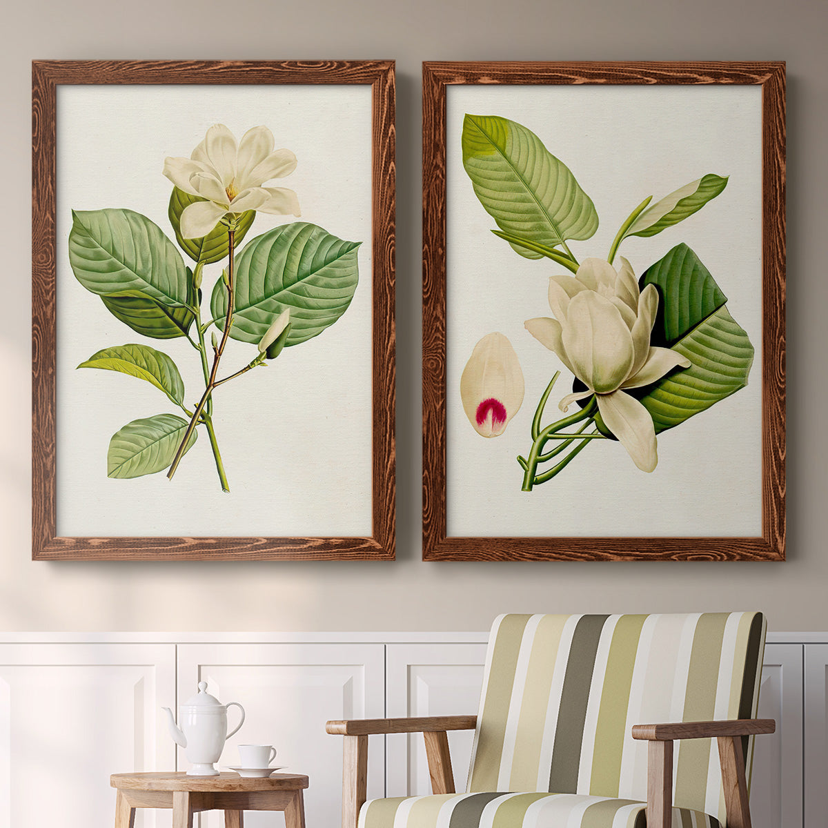 Set of two maple barnwood framed canvas prints depicting two traditional botanical paintings featuring white magnolia blossoms and glossy green leaves above a sideboard in a cozy sitting room.