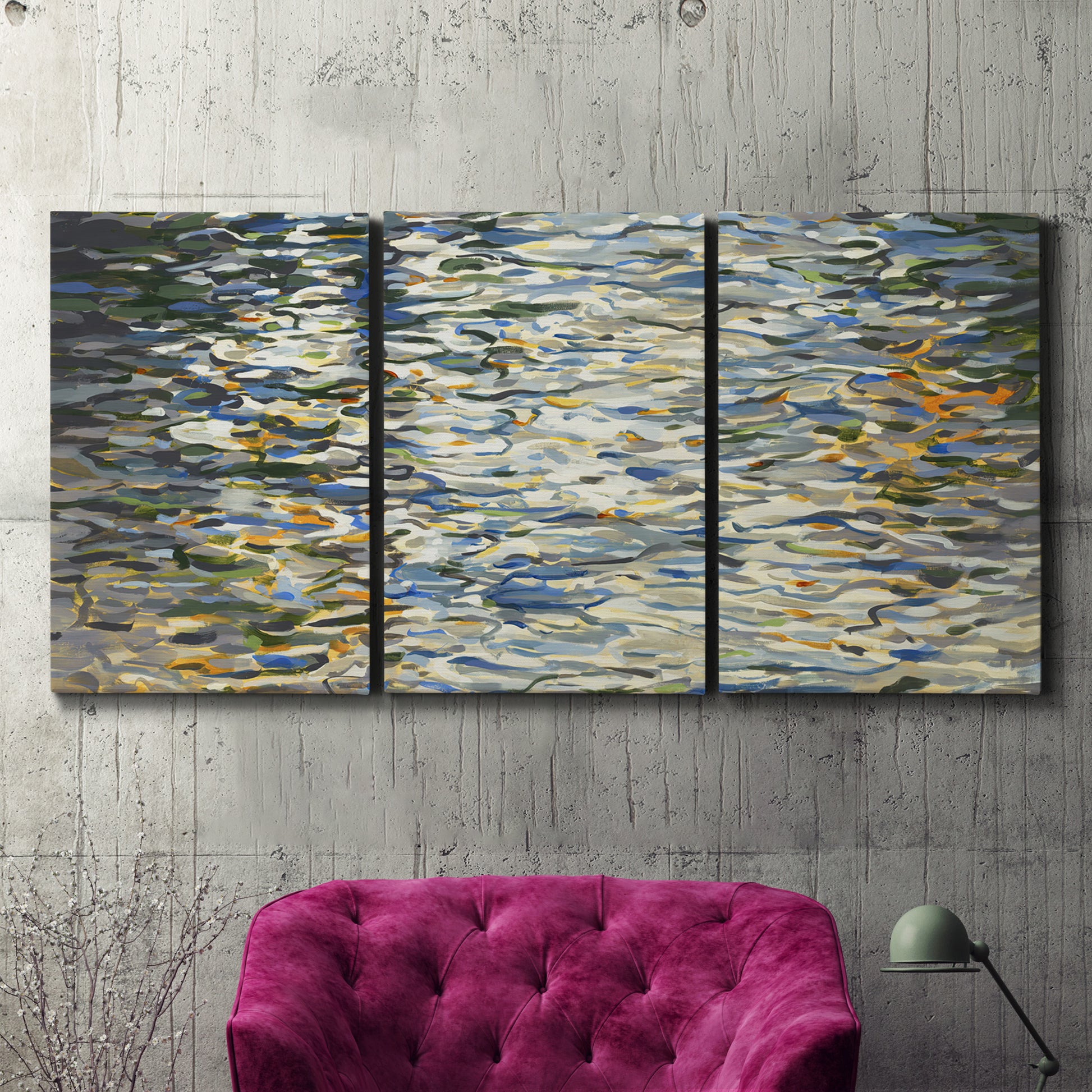 Three-panel canvas wall art featuring abstract water surface reflections, displayed in a living room above a suede accent chair.
