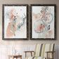 Set of two black barnwood framed canvas prints depicting two abstract watercolor botanicals featuring loose blush gray and coral floral gestures above a sideboard in a cozy sitting room.