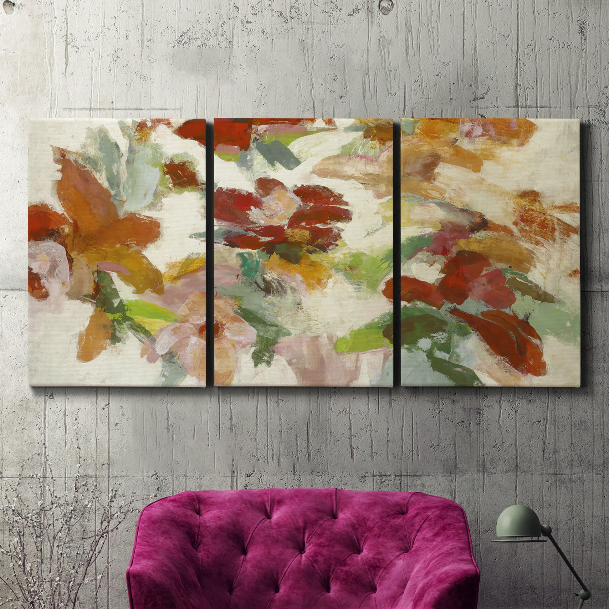 Three-panel canvas wall art featuring layered floral botanical impressions, displayed in a living room above a suede accent chair.