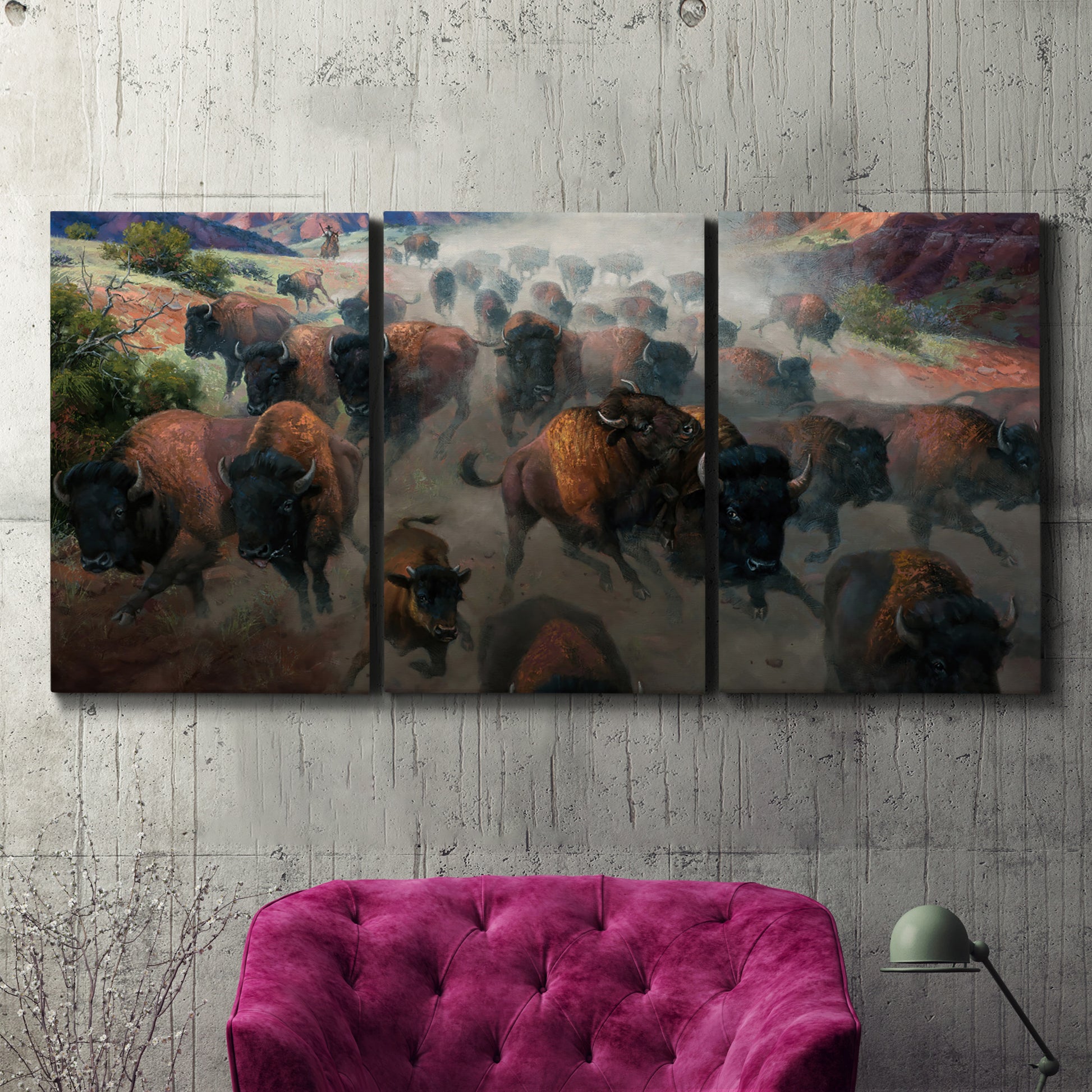 Three-panel canvas wall art featuring stormy canyon landscape with animals, displayed in a living room above a suede accent chair.