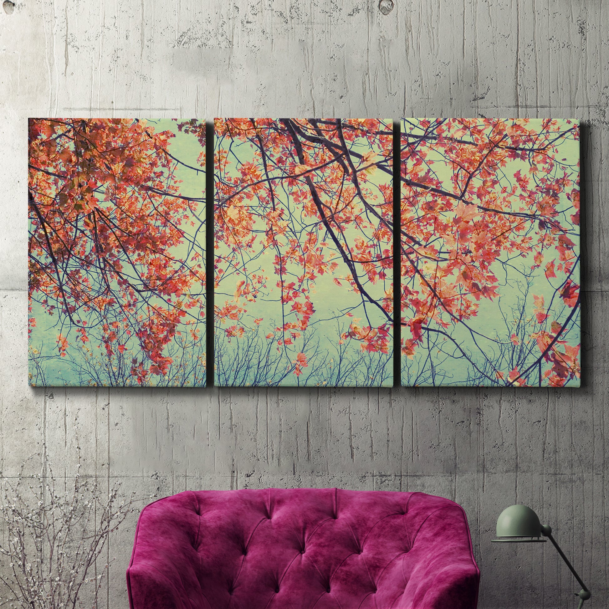 Three-panel canvas wall art featuring autumn foliage landscape photograph, displayed in a living room above a suede accent chair.