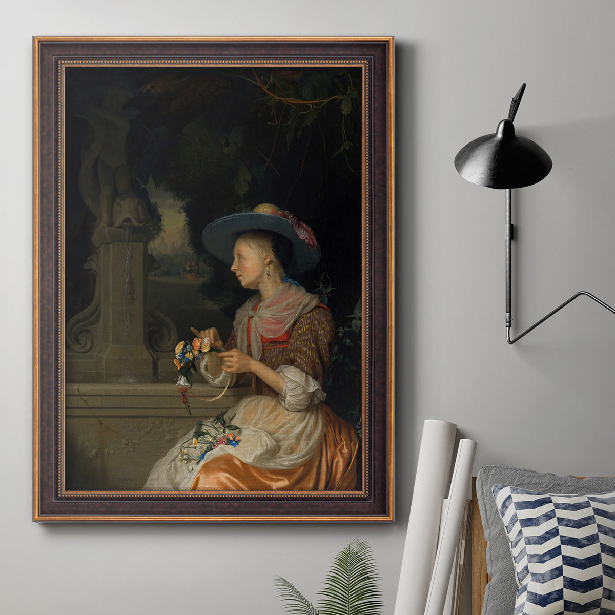 Classical interior scene of a woman weaving flowers by Godfried Schalcken in an ornate bronzed mahogany wood frame displayed in a neutral interior setting.