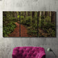 Three-panel canvas wall art featuring forest trail landscape photograph, displayed in a living room above a suede accent chair.