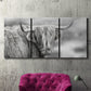 Three-panel canvas wall art featuring large highland cow portrait, displayed in a living room above a suede accent chair.