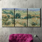 Three-panel canvas wall art featuring lavender sky over quiet landscape, displayed in a living room above a suede accent chair.