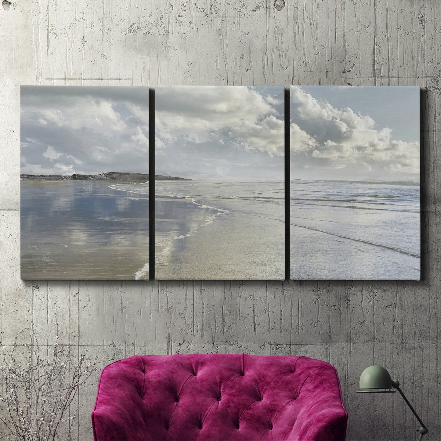 Three-panel canvas wall art featuring endless beach meeting ocean horizon, displayed in a living room above a suede accent chair.