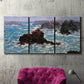 Three-panel canvas wall art featuring storm waves battering rocky coast, displayed in a living room above a suede accent chair.