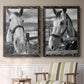 Set of two black barnwood framed canvas prints depicting two modern equestrian photography featuring black-and-white close-up portraits of horses at fences above a sideboard in a cozy sitting room.