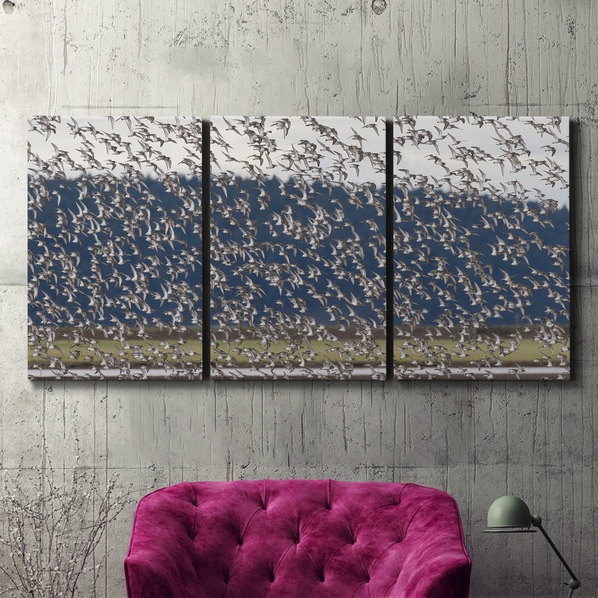 Three-panel canvas wall art featuring group of animals in open field, displayed in a living room above a suede accent chair.