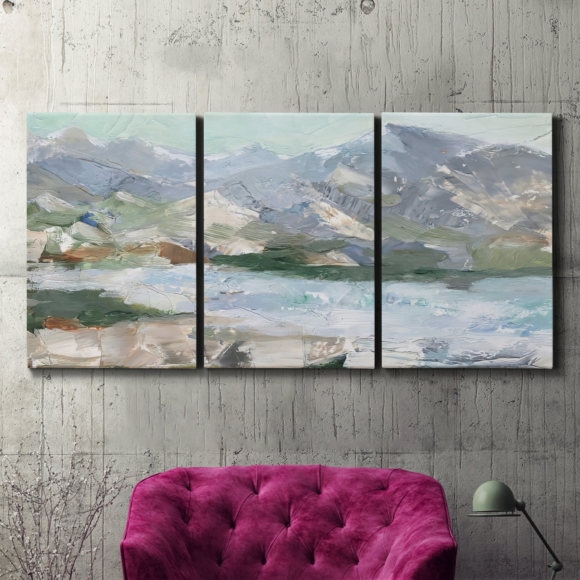 Three-panel canvas wall art featuring pastel mountain landscape view, displayed in a living room above a suede accent chair.