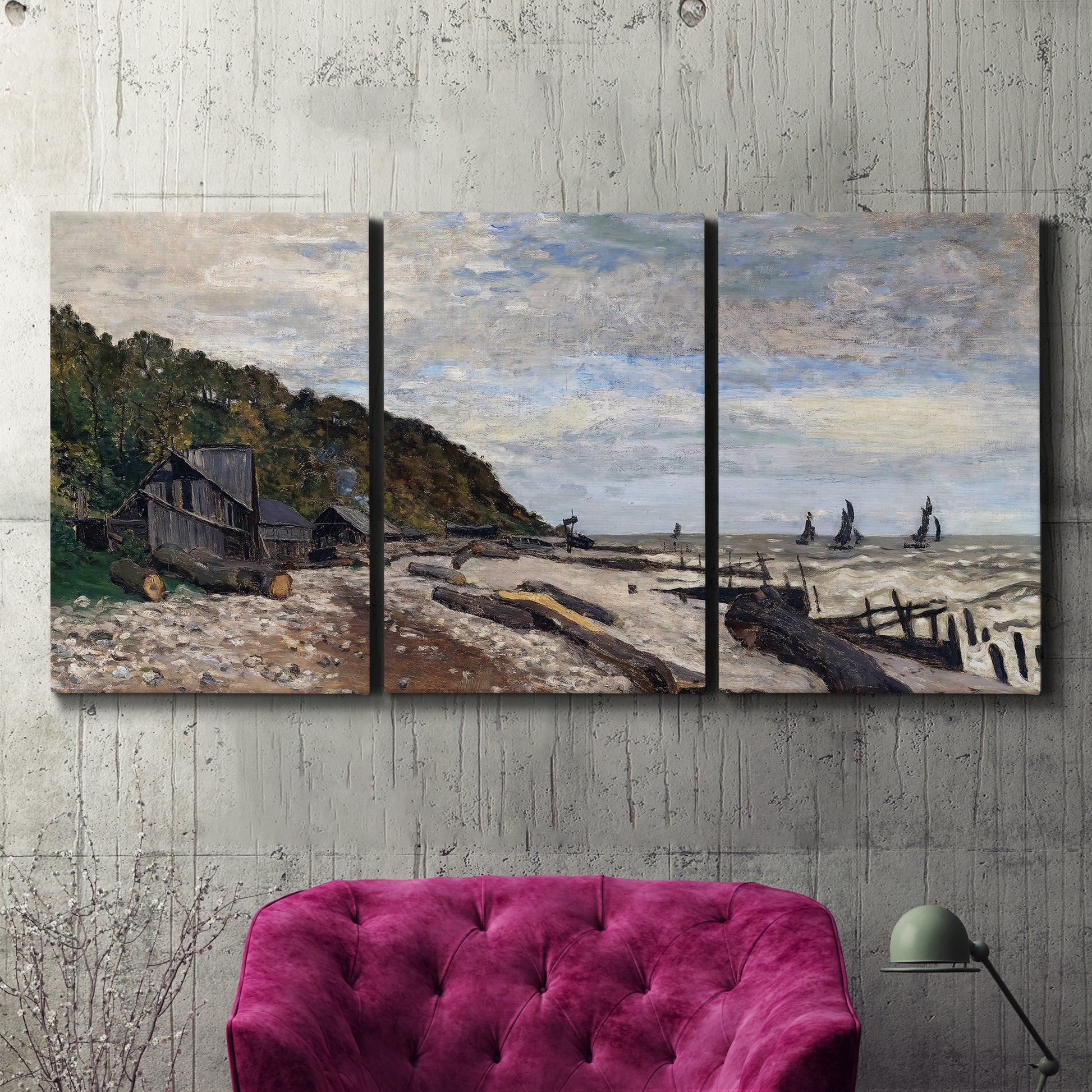 Three-panel canvas wall art featuring open sea along rocky shore, displayed in a living room above a suede accent chair.