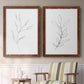 Set of two maple barnwood framed canvas prints depicting two minimalist botanical line drawings featuring single continuous-line leafy branches above a sideboard in a cozy sitting room.