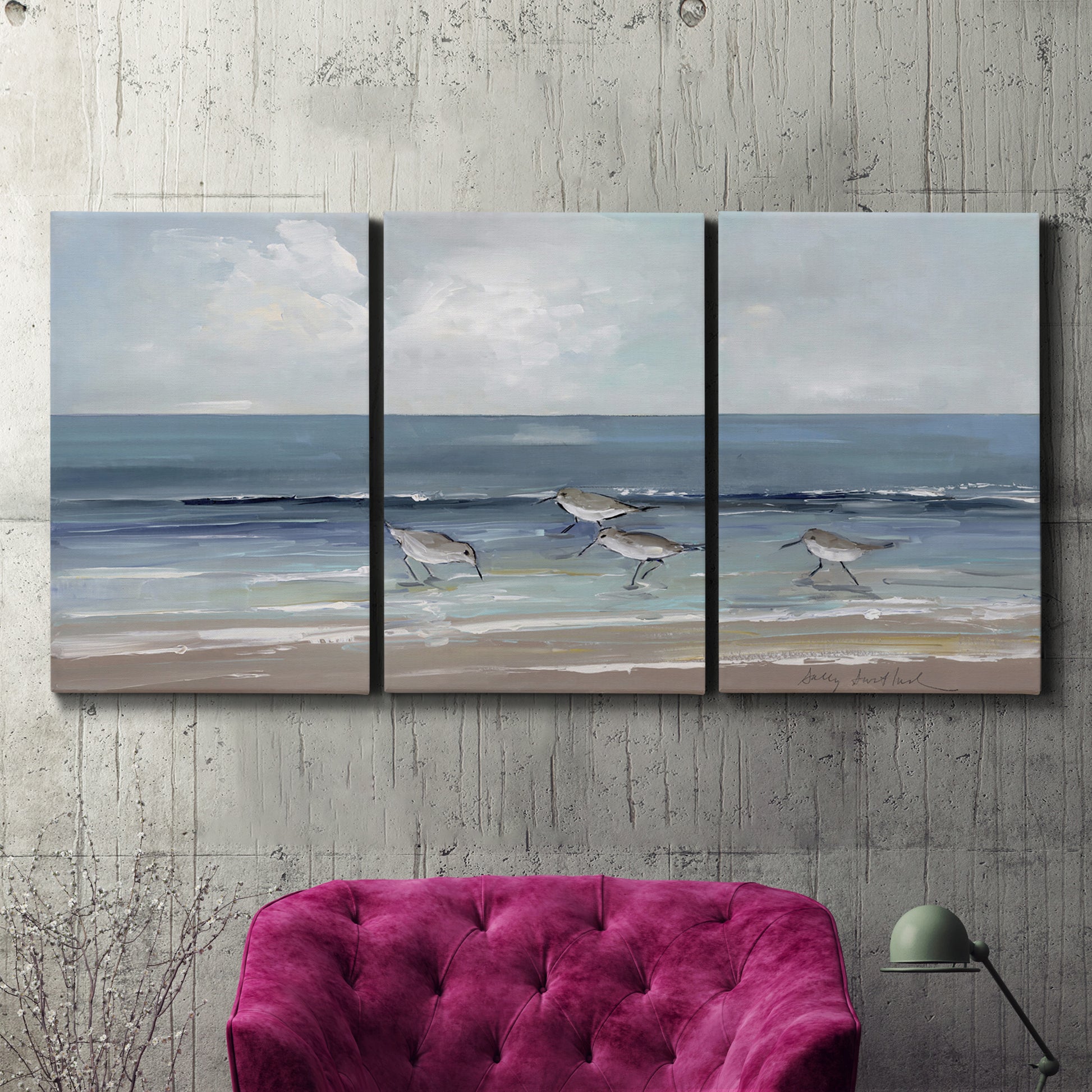 Three-panel canvas wall art featuring shore birds searching along beach, displayed in a living room above a suede accent chair.