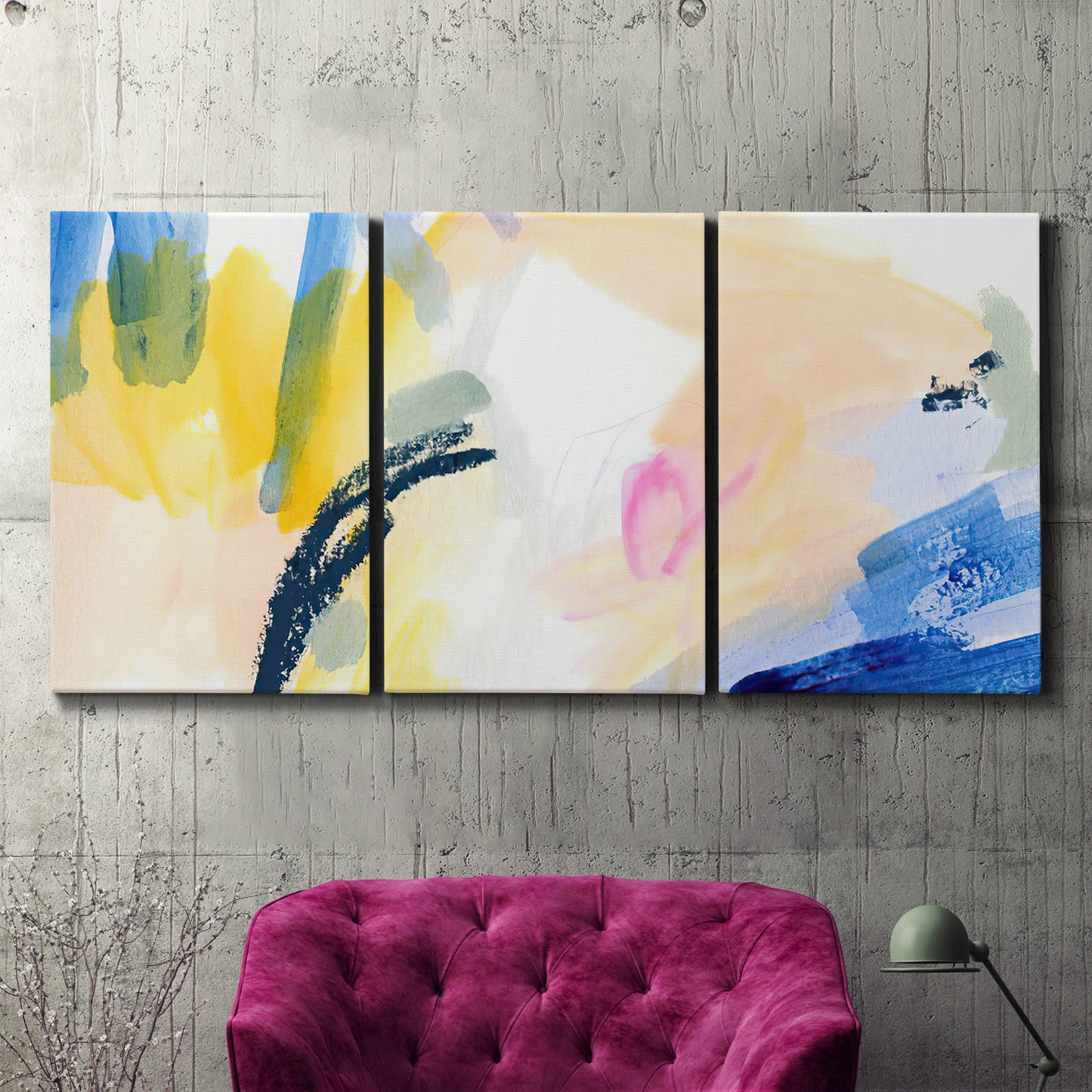 Three-panel canvas wall art featuring bright abstract candy colored strokes, displayed in a living room above a suede accent chair.