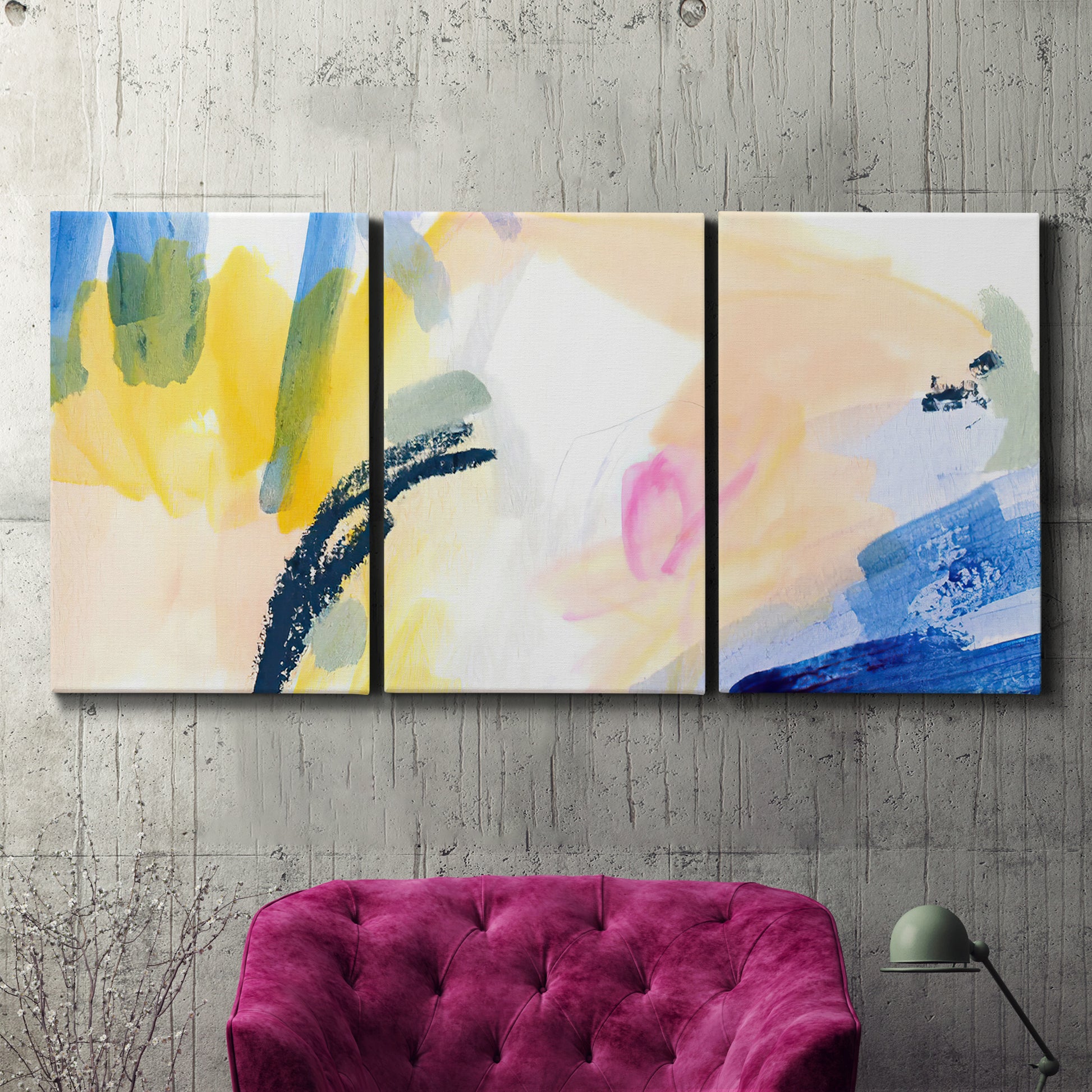 Three-panel canvas wall art featuring bright abstract candy colored strokes, displayed in a living room above a suede accent chair.