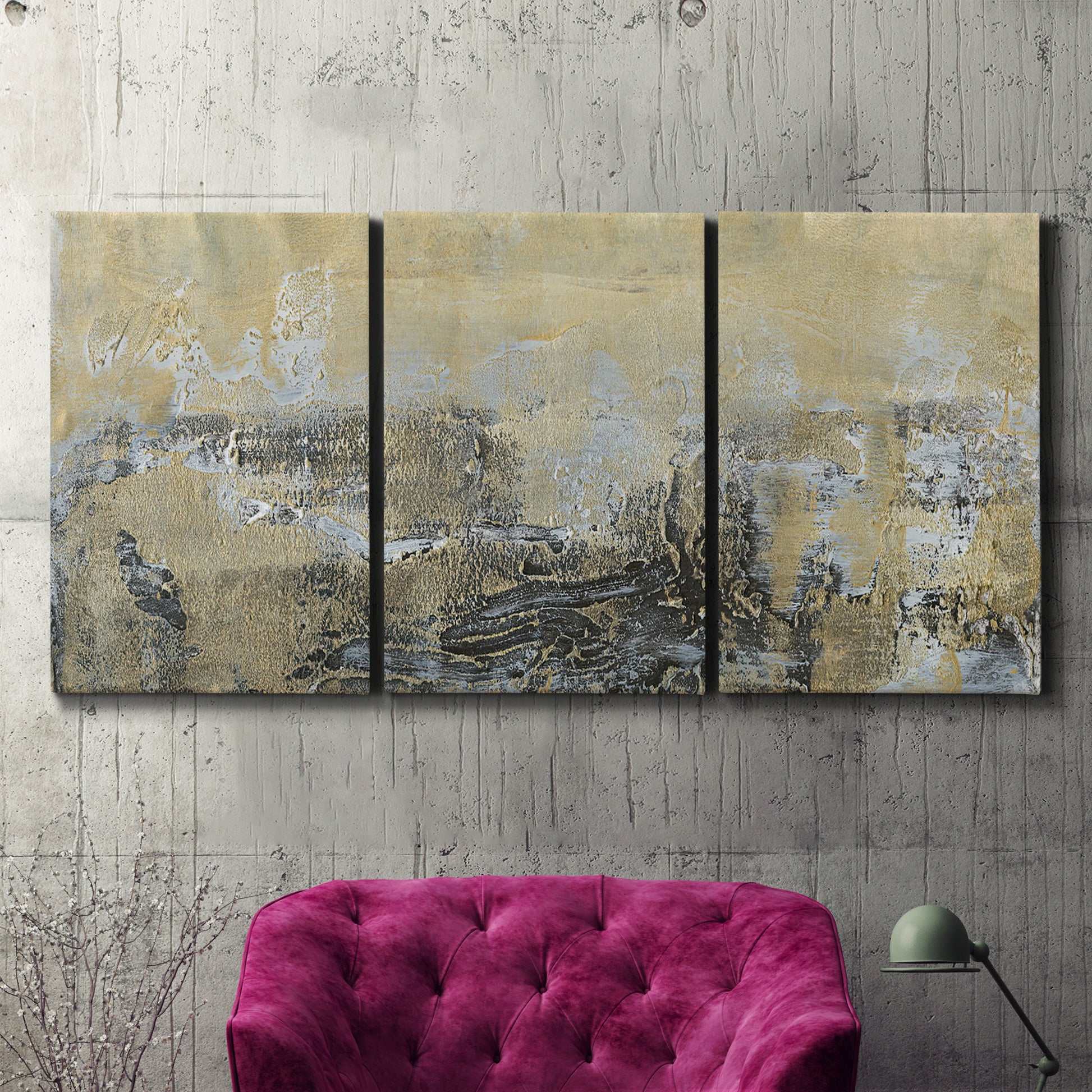 Three-panel canvas wall art featuring gold toned abstract horizon, displayed in a living room above a suede accent chair.