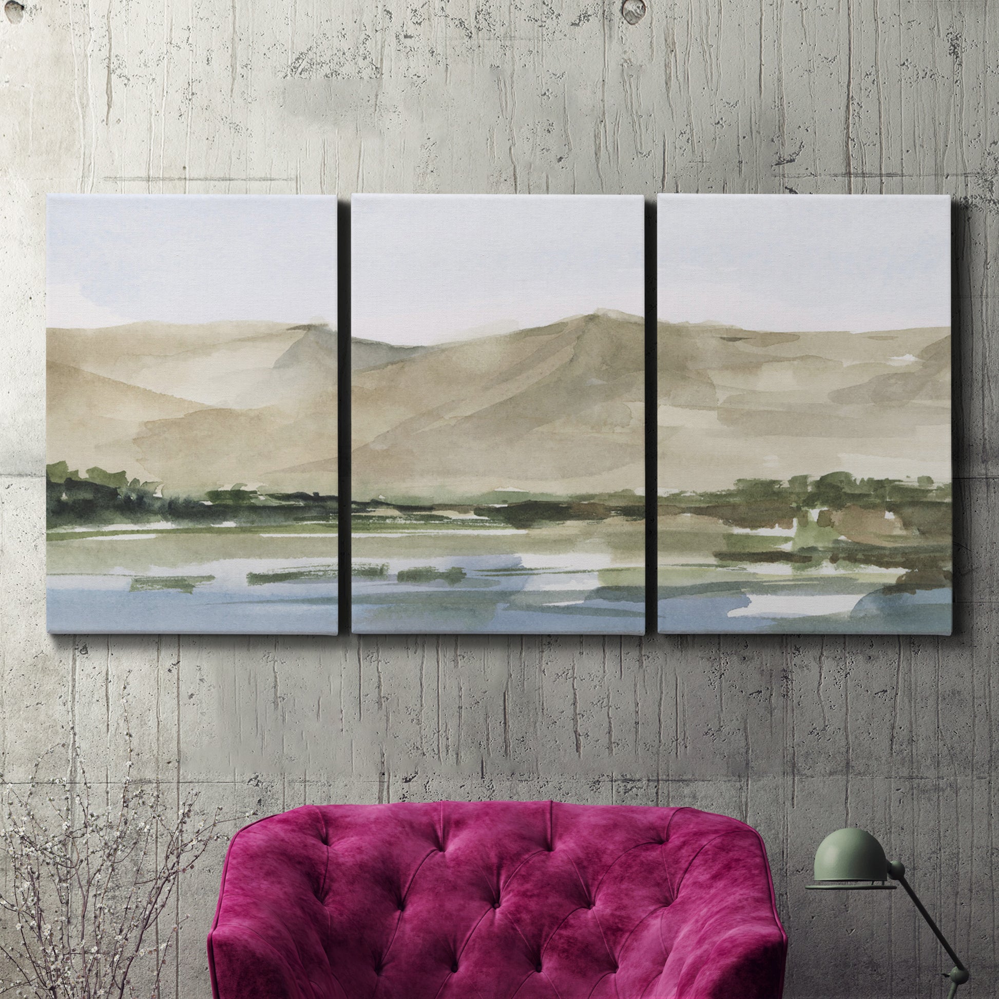 Three-panel canvas wall art featuring desert mountain landscape watercolor, displayed in a living room above a suede accent chair.