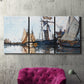 Three-panel canvas wall art featuring fishing boats navigating open water, displayed in a living room above a suede accent chair.