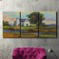 Three-panel canvas wall art featuring rural barn landscape with fields, displayed in a living room above a suede accent chair.