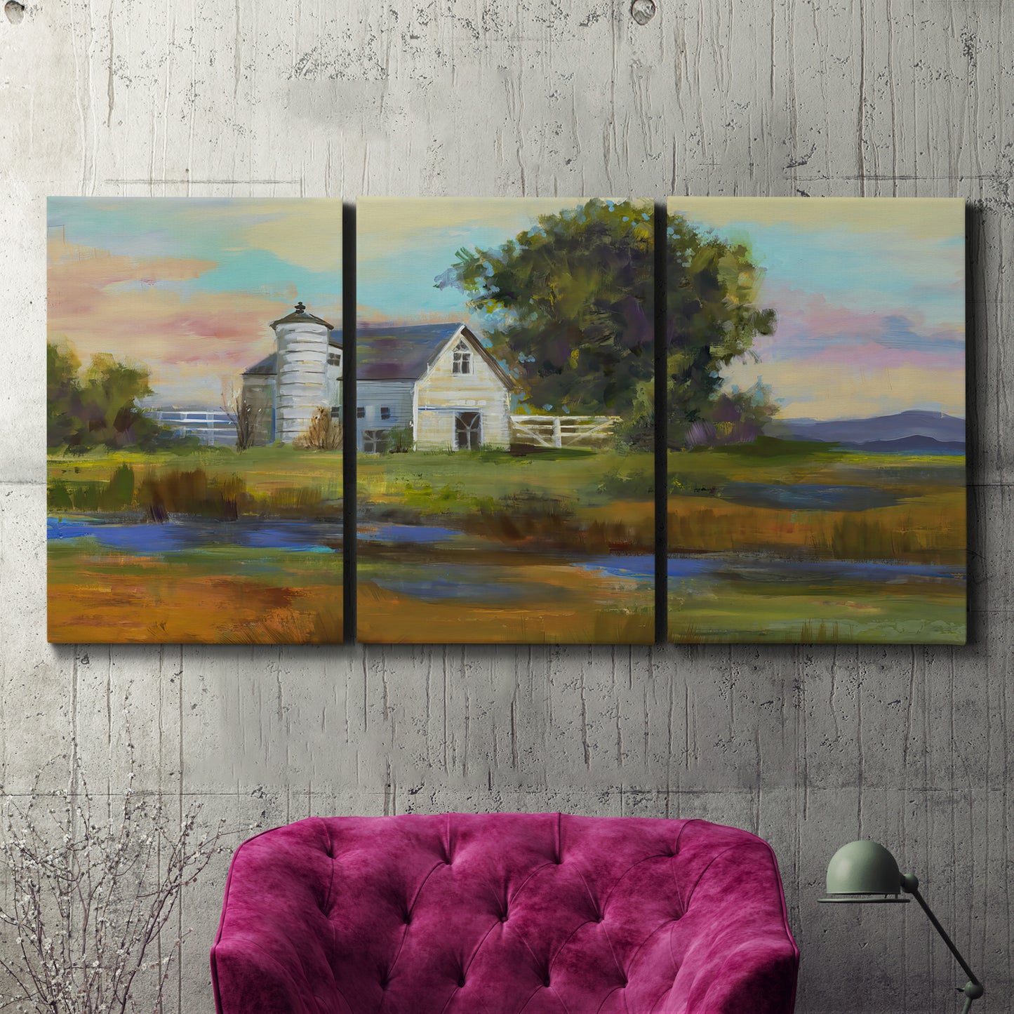 Three-panel canvas wall art featuring rural barn landscape with fields, displayed in a living room above a suede accent chair.